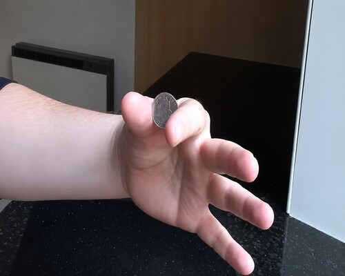 The small coin presented directly towards the audience to hide the larger coins
